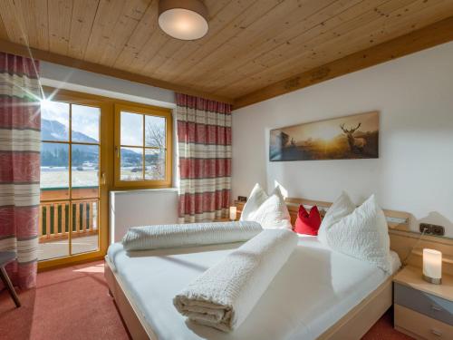 Schlafzimmer mit einem großen weißen Bett und einem Fenster in der Unterkunft Gästehaus Schwaiger - Wiesenweg in Kössen
