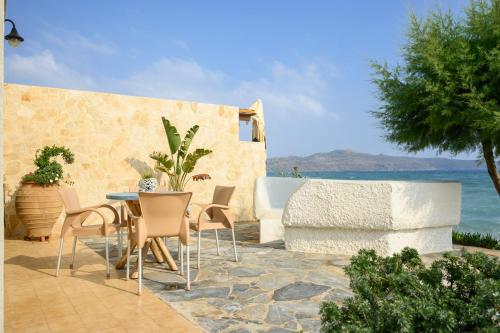 a patio with a table and chairs and the ocean at Hermes Beach Front in Stalos