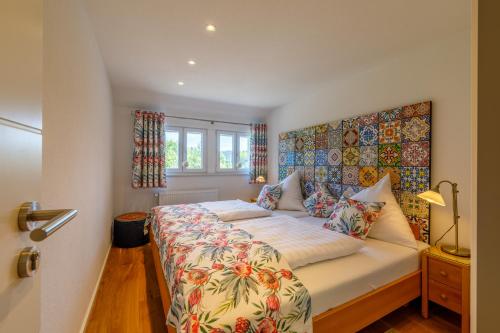 a bedroom with a bed with a floral bedspread at La Felicita 7 in Schluchsee