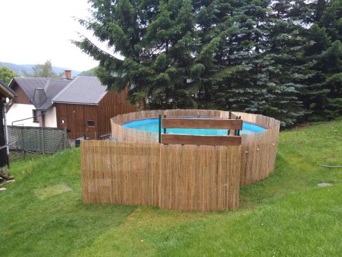 une clôture en bois autour d'une piscine avec un banc dans l'établissement Landidyll, à Breitenbrunn/Erzgeb.
