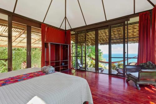 a bedroom with a bed and a view of the ocean at Anamaya Resort in Montezuma