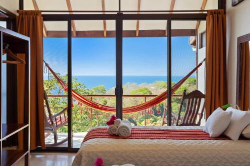 a bedroom with a bed and a large window at Anamaya Resort in Montezuma