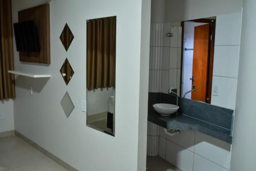 a bathroom with a sink and a mirror at Tangará Hotel in Paraíso do Tocantins