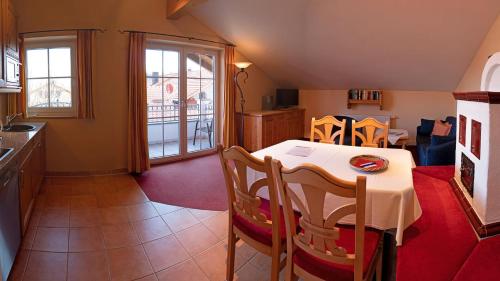 a kitchen and dining room with a table and chairs at Ferienwohnungen am Kurpark in Roßhaupten
