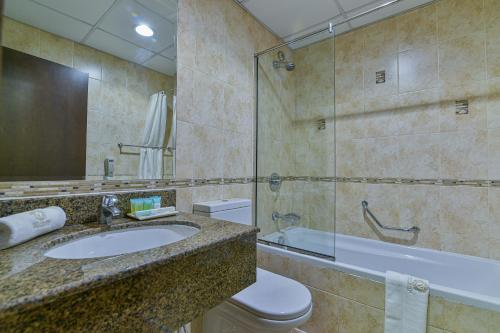 a bathroom with a sink and a toilet and a shower at VISTA HOTEL APARTMENTS DELUXE in Dubai