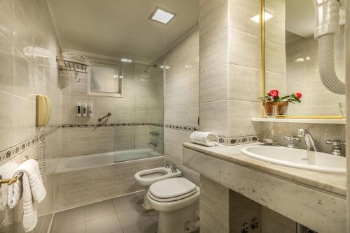 布宜諾斯艾利斯的住宿－Up Viamonte Hotel，浴室配有卫生间、浴缸和水槽。