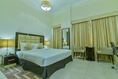 a bedroom with a large bed and a bathroom at VISTA HOTEL APARTMENTS DELUXE in Dubai