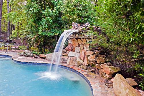 a waterfall in a pool with a stone wall at Lily Creek Lodge in Dahlonega