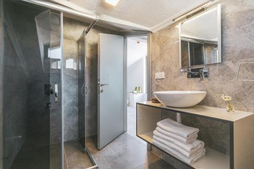 a bathroom with a glass shower and a sink at The Monastery in Oludeniz