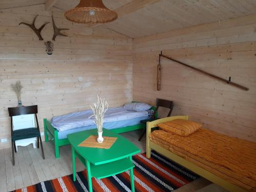 a room with a bed and a table in it at Kadakasuitsu Loodustalu in Saareküla