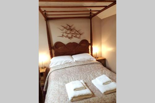a bedroom with a bed with two towels on it at Otters' Raft in Weston-super-Mare