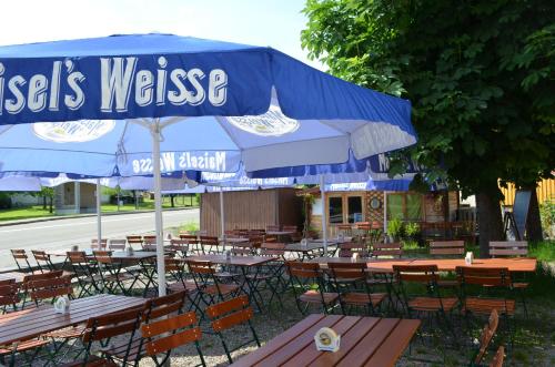 a restaurant with tables and chairs under a blue umbrella at Hotel "Cafe Verkehrt" - Wellcome Motorbiker, Berufsleute und Reisende im Schwarzwald in Oberhof