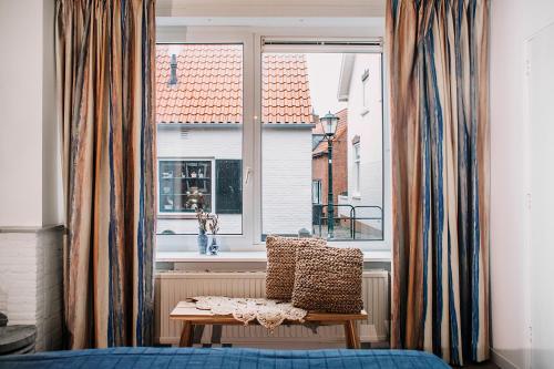 a room with a chair in front of a window at West 7 in Zandvoort