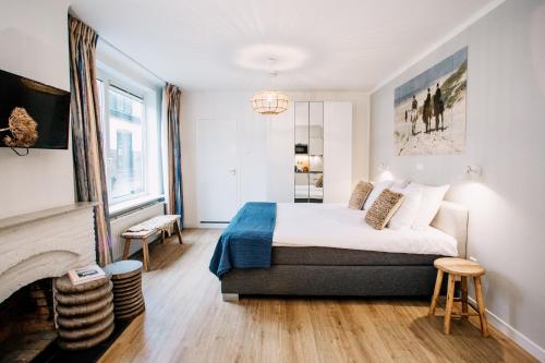 a bedroom with a bed and a fireplace at West 7 in Zandvoort