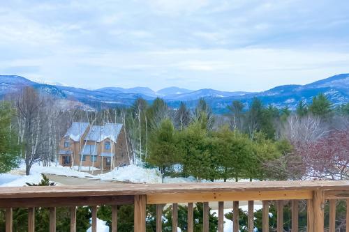 a house with a snow covered roof on a deck at Attitash Woods Escape in Bartlett