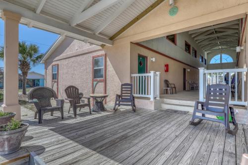 eine Veranda mit Stühlen und einem Tisch auf einem Haus in der Unterkunft La Playita & Flip Flop Fun in St. George Island