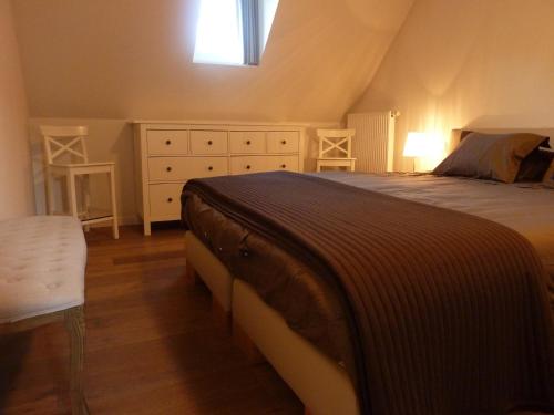 ein Schlafzimmer mit einem Bett, einer Kommode und einem Fenster in der Unterkunft Albertushof in Ypern