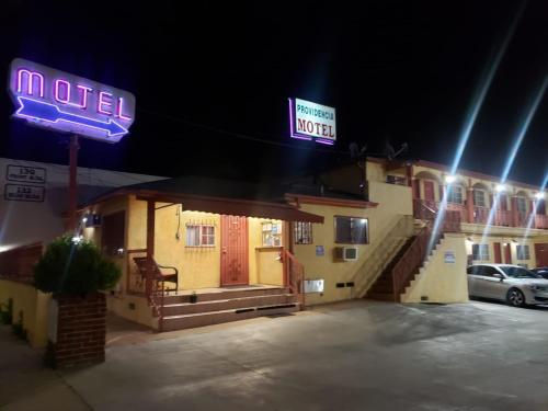 a hotel with a neon sign in a parking lot at Providencia Motel in Burbank