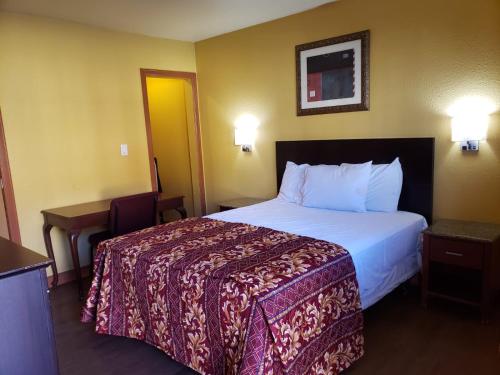 a hotel room with a large bed and a table at Providencia Motel in Burbank
