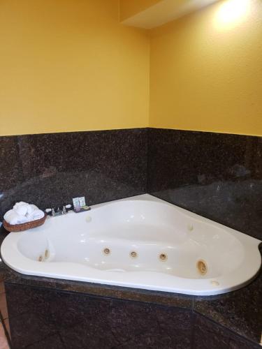 a white bath tub in a bathroom with a yellow wall at Providencia Motel in Burbank