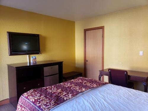 a hotel room with a bed and a flat screen tv at Providencia Motel in Burbank