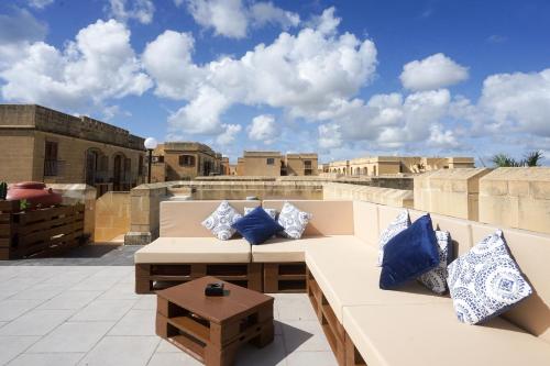 patio na dachu z ławką i niebieskimi poduszkami w obiekcie GetawayNpetto Private Duplex Maisonette with Jacuzzi Hot Tub w mieście Mġarr