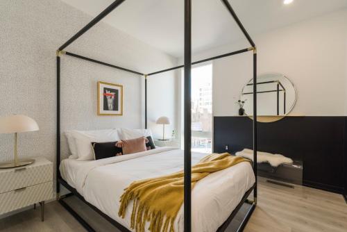 een slaapkamer met een hemelbed en een gouden deken bij Abode XS House Stunning Architectural Flat in Philadelphia