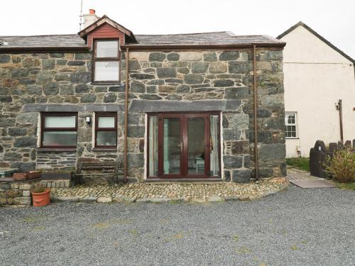 an old stone house with a red door at Hafod in Llanddeiniolen