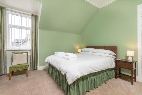 a bedroom with a bed and a chair and a window at Convalmore House in Dufftown