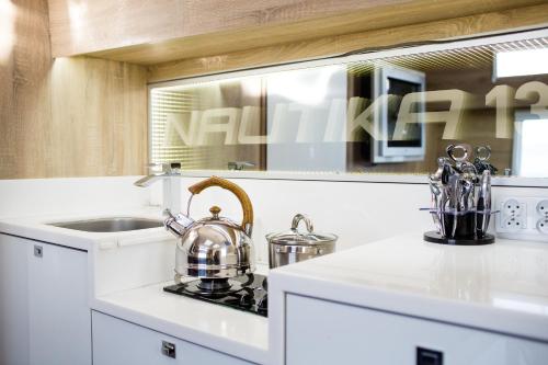 a kitchen with a sink and a tea kettle on a counter at Jacht motorowy Nautika 1300 VIP in Wilkasy