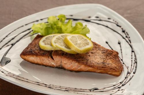 a plate with a piece of fish with lemon slices on it at Hotel Econohotel in Los Ángeles