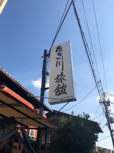una señal para un restaurante con escritura asiática en él en Takigawa Ryokan, en Kioto
