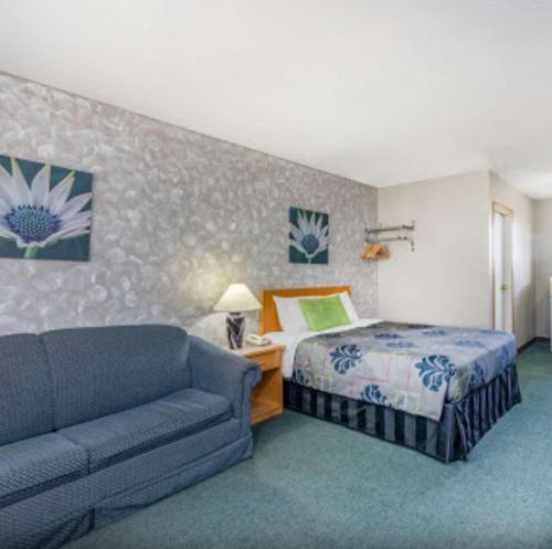Habitación de hotel con cama y sofá en Almada Inn, en Fort Nelson