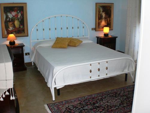 ein Schlafzimmer mit einem weißen Bett mit zwei Lampen an Tischen in der Unterkunft Ai Limoni in Paceco