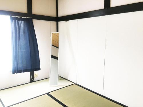 a room with white cabinets and a blue curtain at Oasis Wadaura in Minamiboso