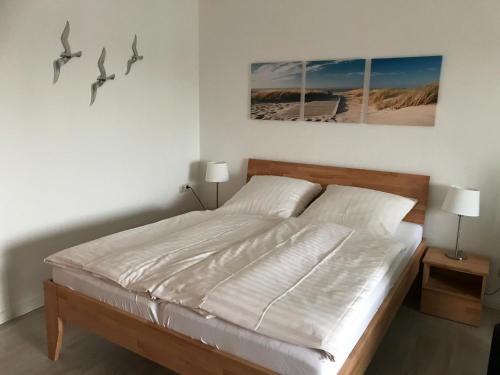 a bedroom with a bed with two birds on the wall at Steiner Strandappartements Appartement 208 Süd- Landseite in Stein