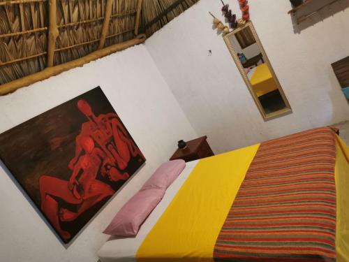 a bedroom with a bed with a colorful blanket at La Máxima & LGBT in Zipolite
