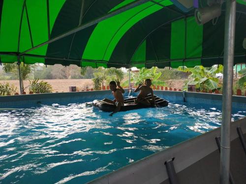 a couple of people sitting in a swimming pool at Touch the Wind in Chaiyaphum