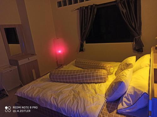 a bed with pillows on it in a bedroom at Touch the Wind in Chaiyaphum