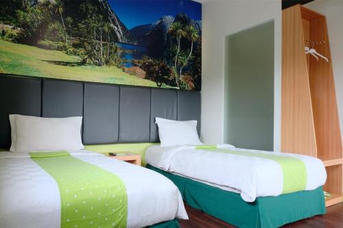 dos camas sentadas una al lado de la otra en una habitación en Arbor Biz Hotel, en Makassar
