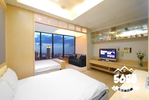 a bedroom with a bed and a flat screen tv at 85 Vacation ApartHotel in Kaohsiung