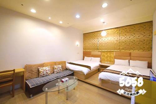a hotel room with two beds and a couch at 85 Vacation ApartHotel in Kaohsiung