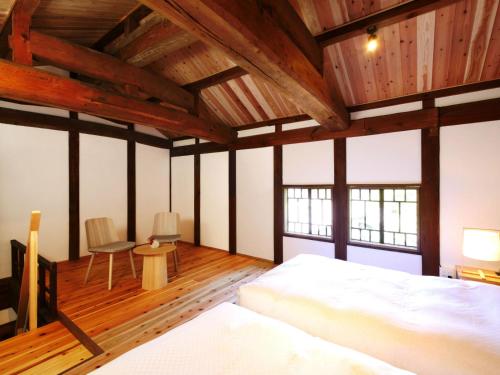 a bedroom with a bed and a table and chairs at NIPPONIA HOTEL Takehara Saltworks Town in Takekara