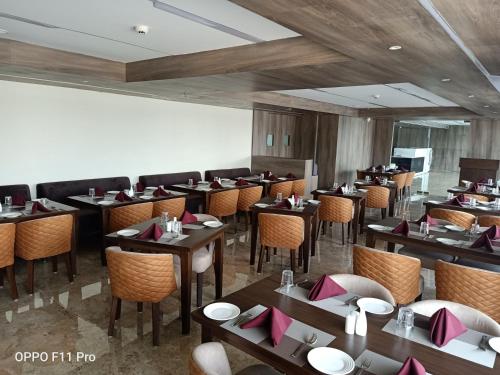 una sala da pranzo con tavoli e sedie in un ristorante di The Hotel Celebration a Balāngīr