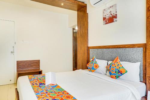 a bedroom with a white bed with a wooden headboard at FabHotel Gravity Inn Baner in Pune