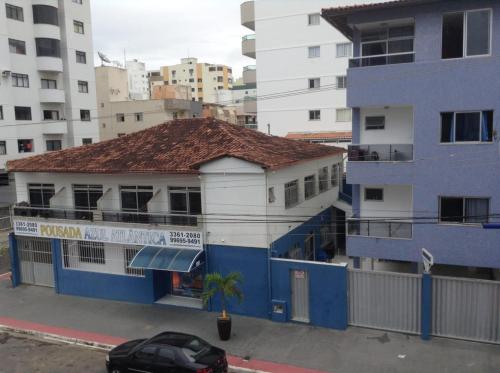 a blue and white building with a car parked in front at Pousada Azul Atlântica in Guarapari