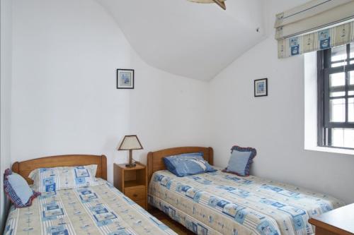 a bedroom with two beds and a window at Captain Pisco's Palheiro - Great Location in Costa Nova
