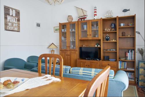 a living room with a dining room table and a tv at Captain Pisco's Palheiro - Great Location in Costa Nova