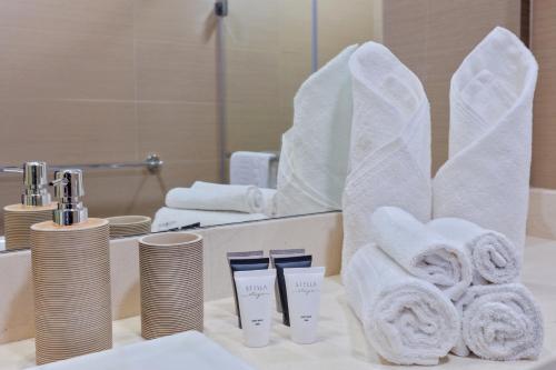 a bathroom with towels and a sink with a mirror at Stella Stays Modern 2BDR Dubai JBR Beach Netflix in Dubai