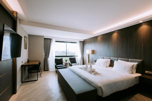 um quarto de hotel com uma cama grande e uma secretária em The Rich Hotel em Nakhon Ratchasima